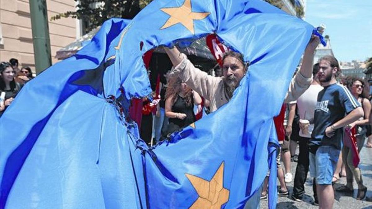 Partidarios del 'no' en el referéndum queman una bendera de la Unión Europea en Grecia durante una protesta en Atenas, ayer.