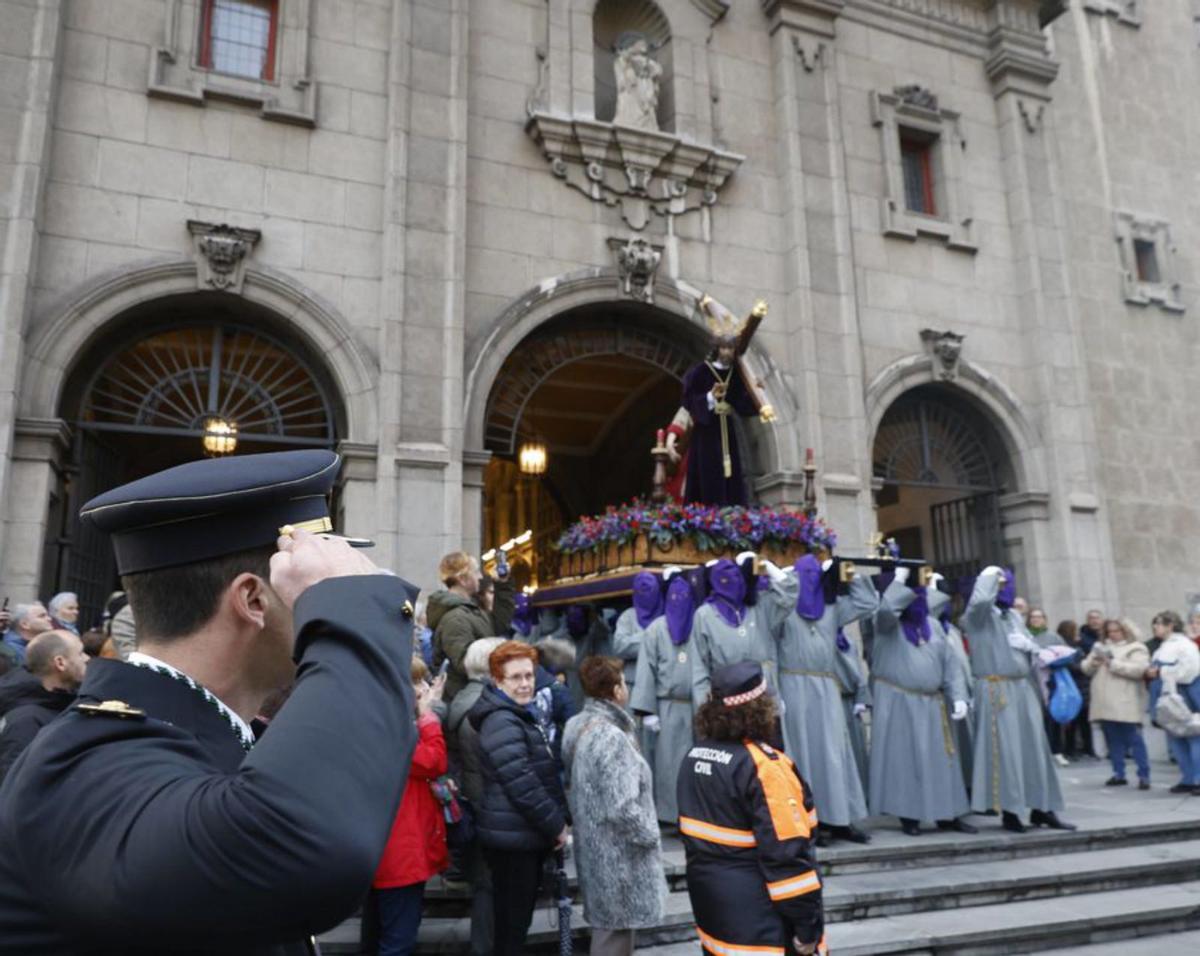 Un agente de la Policía Nacional, saludando a la salida de San José a los hermanos de la Vera Cruz que portaban el paso del Nazareno. | MARCOS LEÓN