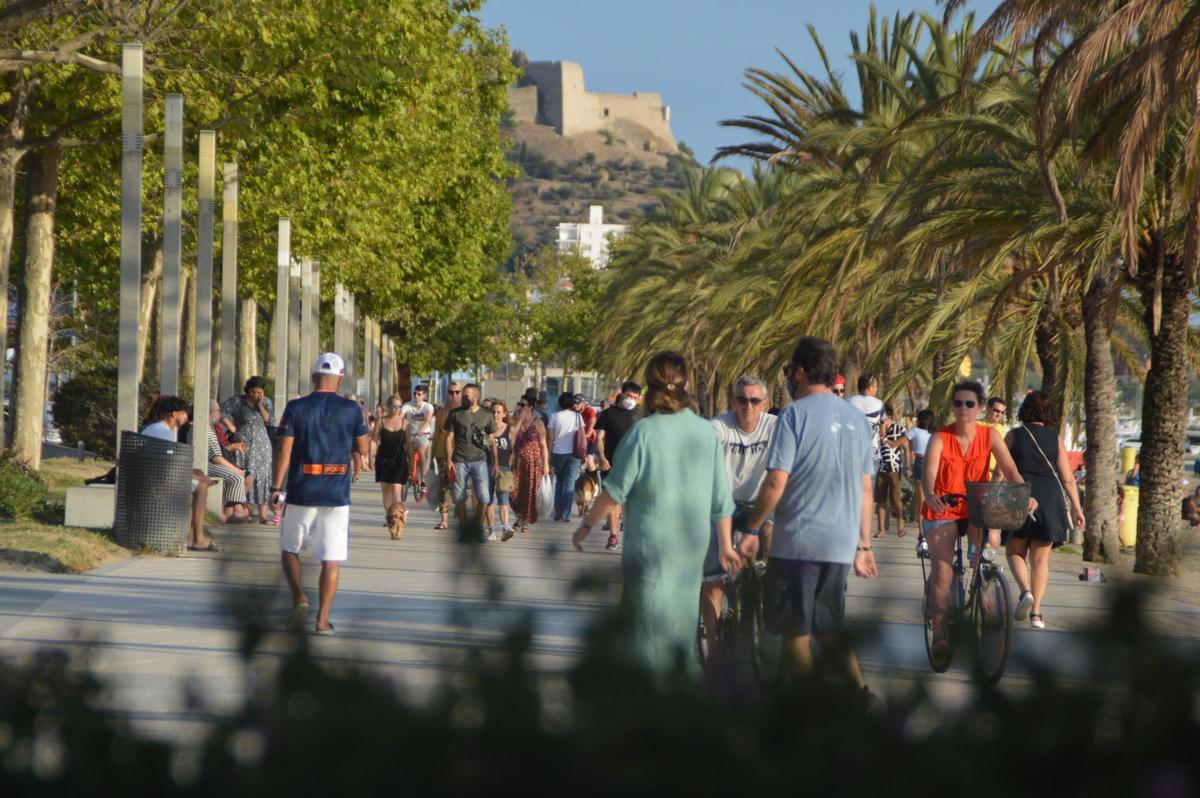 Persones passejant al passeig marítim de Roses.