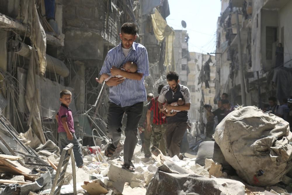 Dos homes sirians rescaten a dos nadons d'una zona destruïda per un bombardeig a Alep