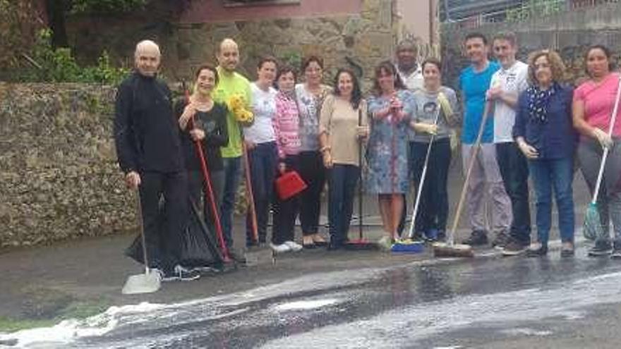 Los padres de los niños que harán su primera comunión mañana en Arriondas con el material para limpiar la iglesia.