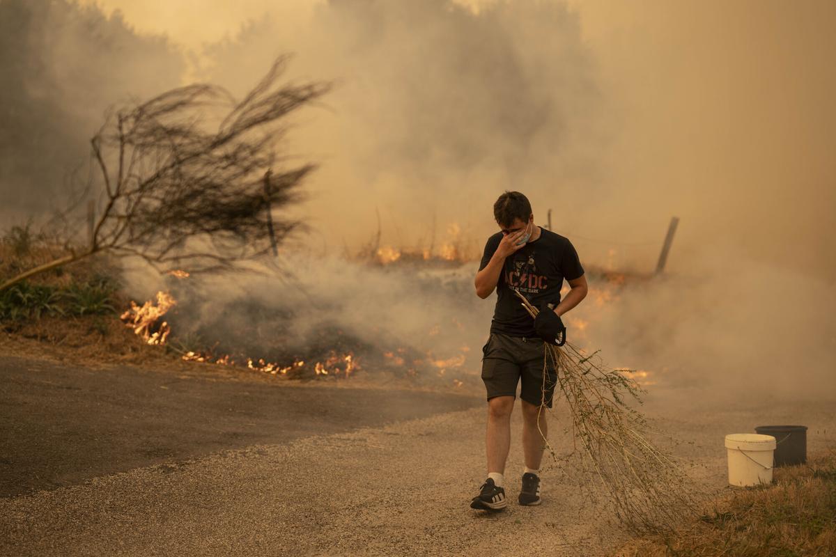 trabajan en labores de extinción del incendio forestal de Carballeda de Avia (Ourense) este domingo. La ola de incendios que afecta al noroeste de España no da tregua este domingo. Tras una semana de incendios que han causado tres muertos, miles de hectáreas quemadas y miles de desalojados por las llamas, el país se encuentra devastao. En la región de Galicia ardieron ya 50.000 hectáreas y en la de Castilla y León 3.500 personas permanecían fuera de sus hogares. EFE/ Brais Lorenzo