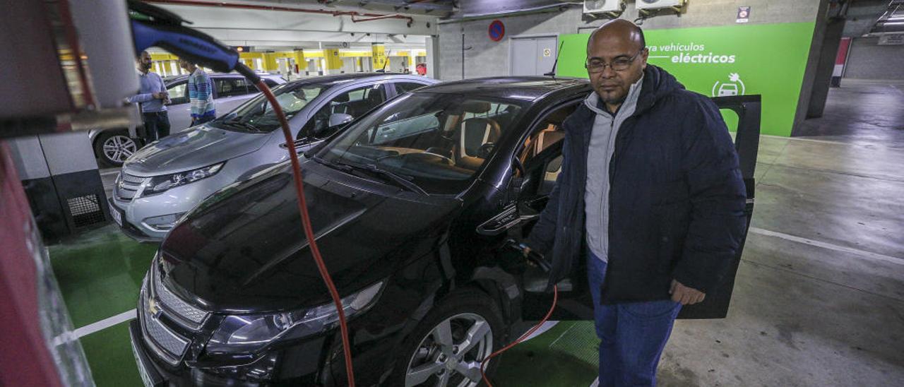 Un hombre en un punto de carga para vehículos eléctricos en el centro comercial L&#039;Aljub de Elche.