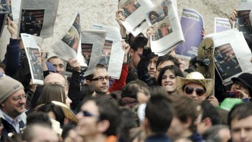 Un grupo de asistentes a la Mascletá, que ha tenido lugar hoy en la plaza del Ayuntamiento de Ayuntamiento de Valencia, muestran los catálogos de la exposición &quot;Fragments d un any&quot; que fue reinaugurada ayer tras su retirada del Museo Valenciano de la Ilustración y Modernidad.