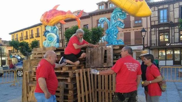 Responsables y socios del colectivo trabajan en el montaje de la hoguera de San Juan.