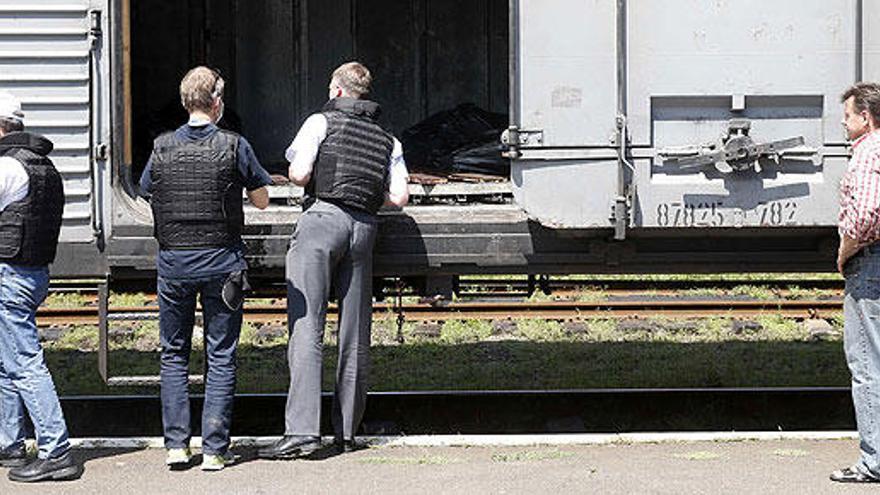 Miembros de la OSCE inspeccionan un vagón con cadáveres.