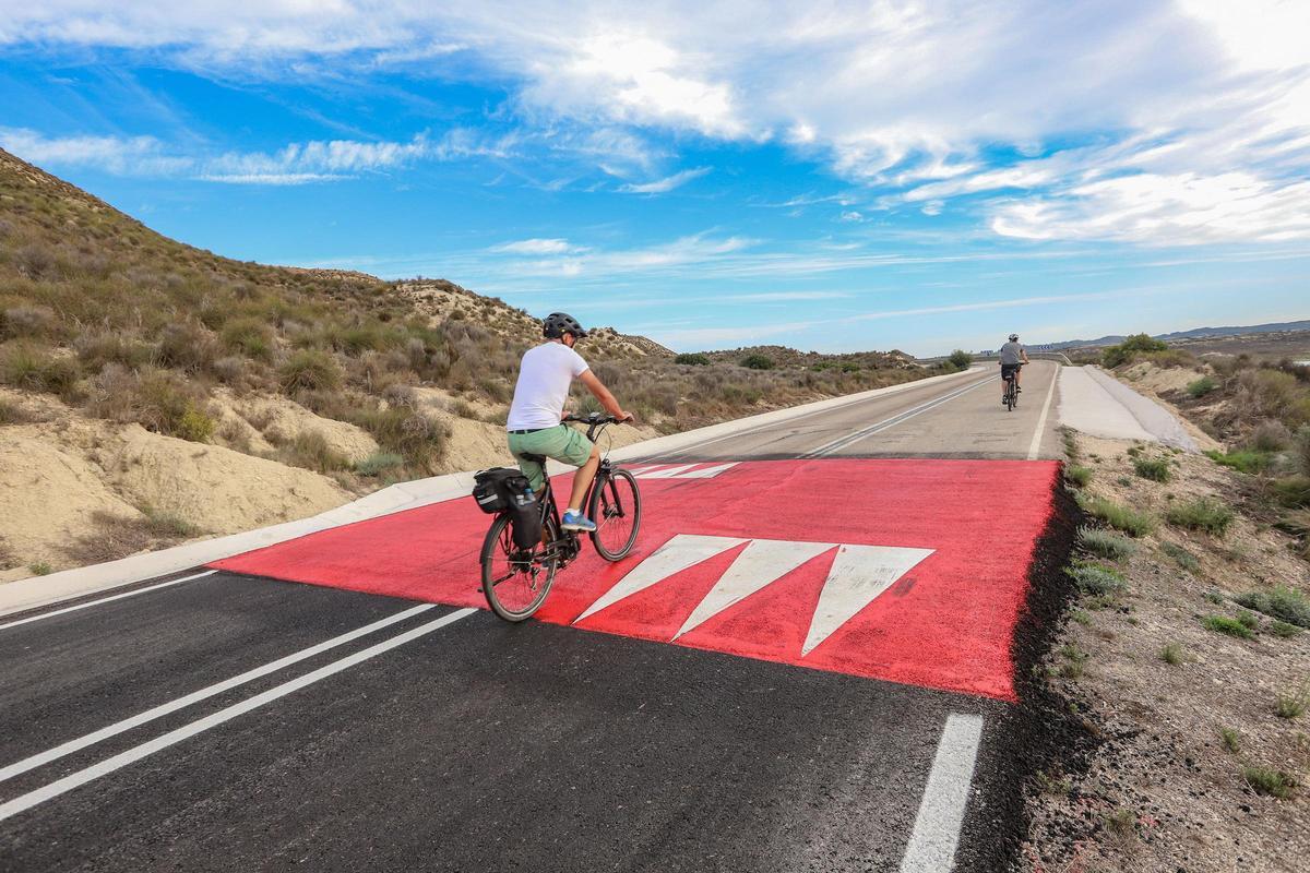 Reductores en la carretera del embalse de La Pedrera, al fondo de la imagen