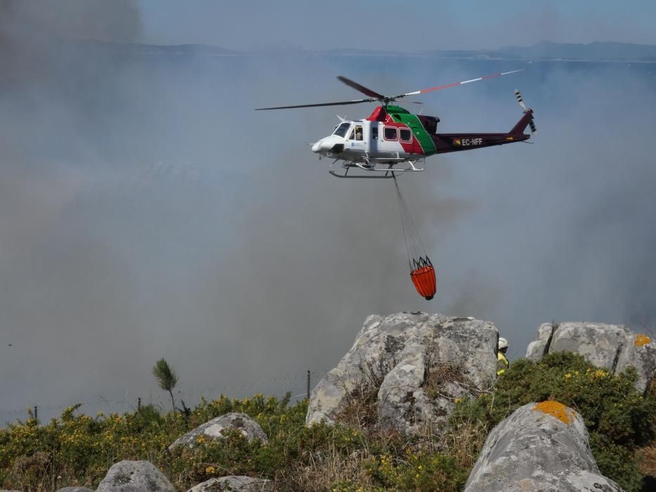 Las exhaustas labores de extinción del incendio de Cangas. // S. Álvarez