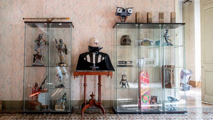 Un busto de Darth Vader entre figuras de Boba Fett, un prototipo de la cabeza del Johnny 5 de ‘Cortocircuito’, el &#039;skate&#039; volador de ‘Regreso al futuro 2’ y una réplica del juego de &#039;Jumanji&#039;, entre otras reliquias cinéfilas.