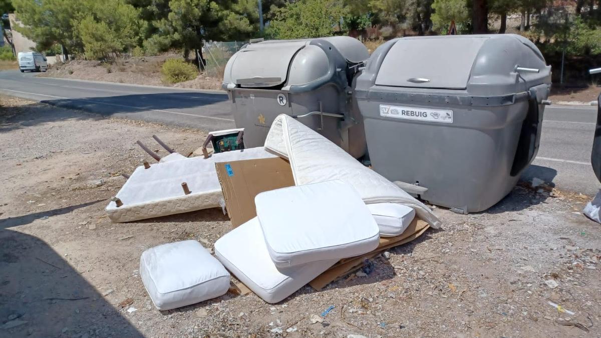 Imagen de colchones y otros desechos vertidos junto a dos contenedores en una zona residencial de l'Alfàs.