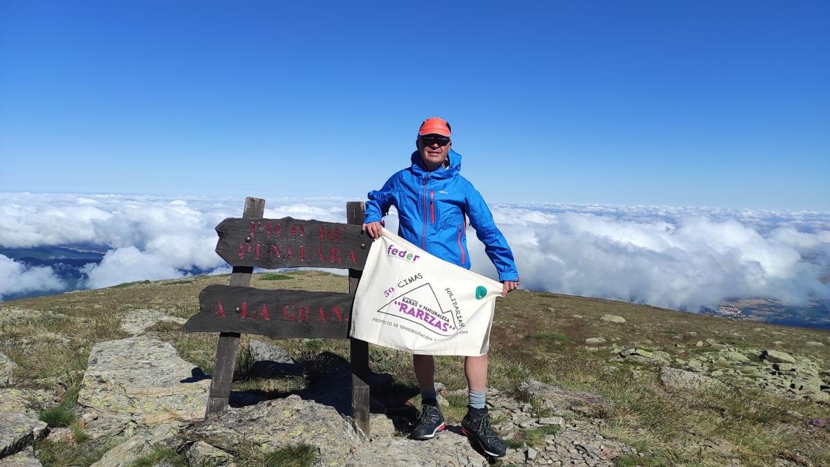 El grausino David Cagigós muestra la bandera en lo alto del Peñalada, cima más alta de Madrid y Segovia.