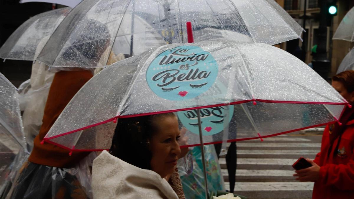 Falleras desfilando en la ofrenda bajo la lluvia el pasado martes en València.