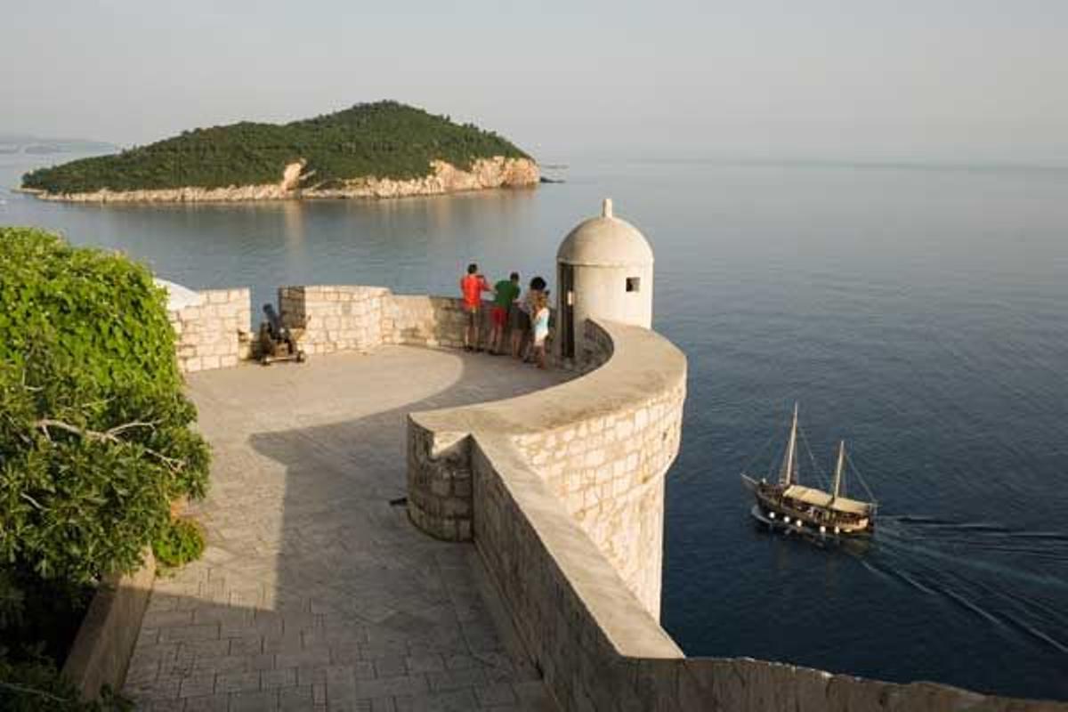 Turistas en la muralla de Dubrovnik con la isla de Lokrum al fondo, sobre el mar Adriático.