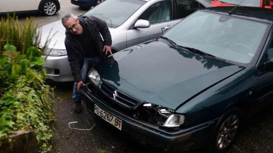 El vecino de Aldán muestra los daños del jabalí en su coche. // Gonzalo Núñez