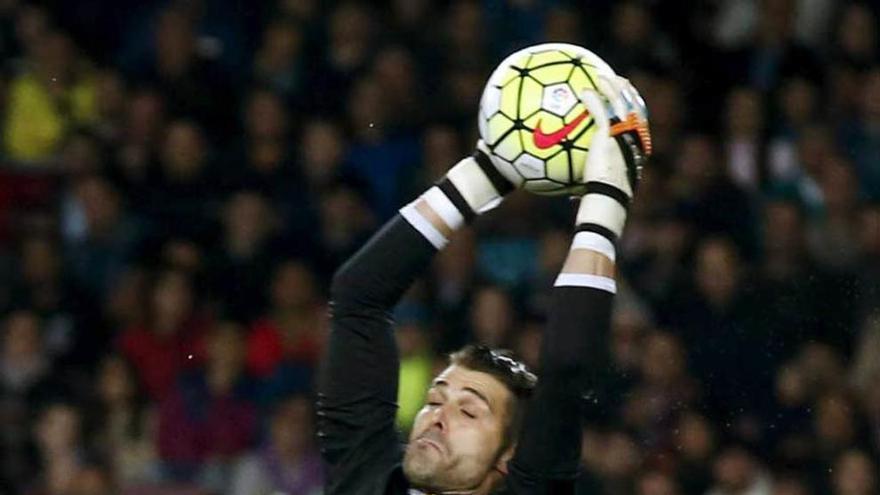 Cuéllar bloca el balón ante la mirada de Piqué.