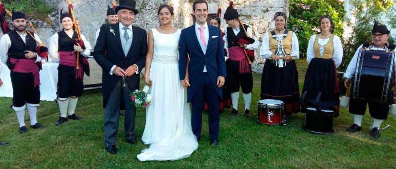 Los novios, Carmen Rodríguez de Andrés e Ignacio Sáez, junto al padrino, Pedro Rodríguez Inciarte, y la banda de gaitas, ayer, en El Cercáu, en Llanes.