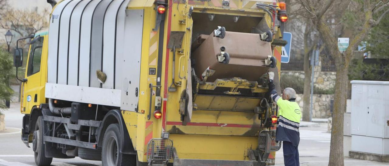 Un operario descarga un contenedor en un camión de residuos en Ontinyent. | PERALES IBORRA