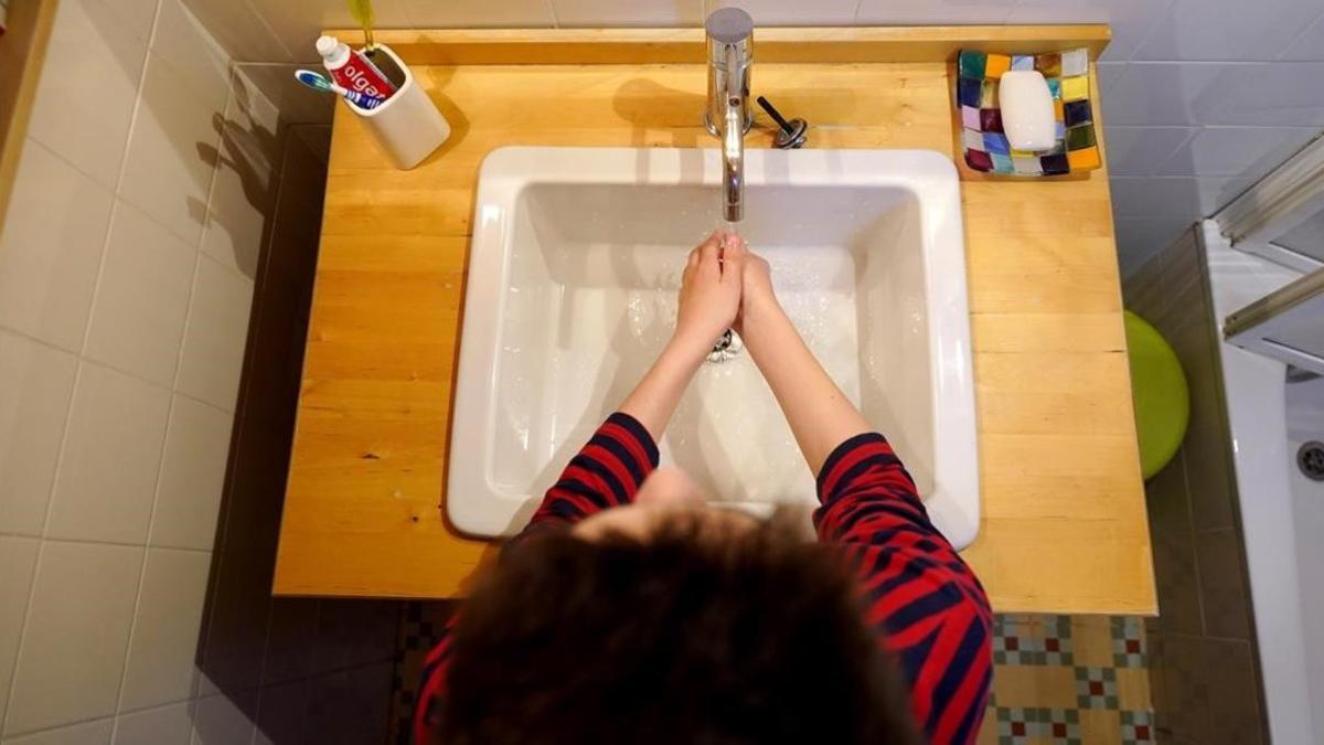 Un niño se lava las manos en su casa como medida de precaución frente al coronavirus