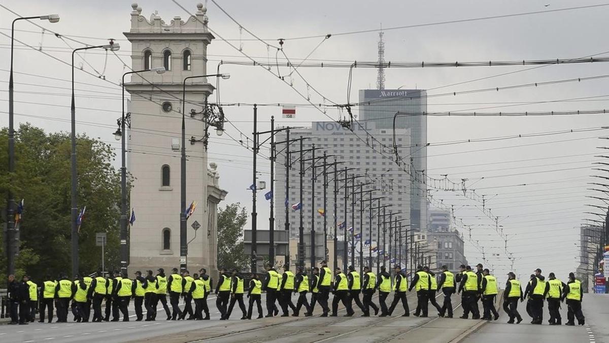 Varios policías caminan hacia el estadio nacional donde se celebrará la cumbre.