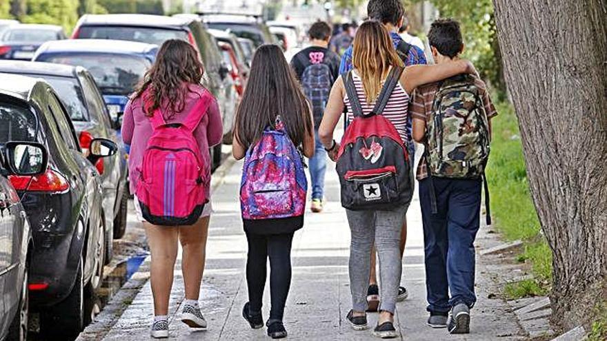 Alumnos con mochilas en el entorno de un centro educativo.