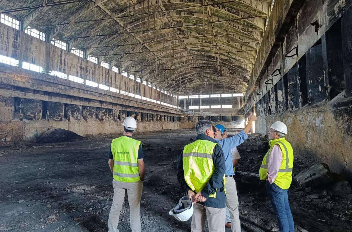 Técnicos y representantes del Ayuntamiento de Langreo en  una de las naves de Nitrastur. |