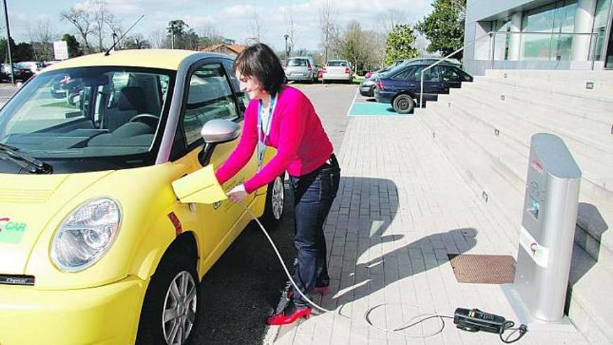 Paula Queipo enchufa su coche eléctrico en uno de los postes de recarga de Gijón.