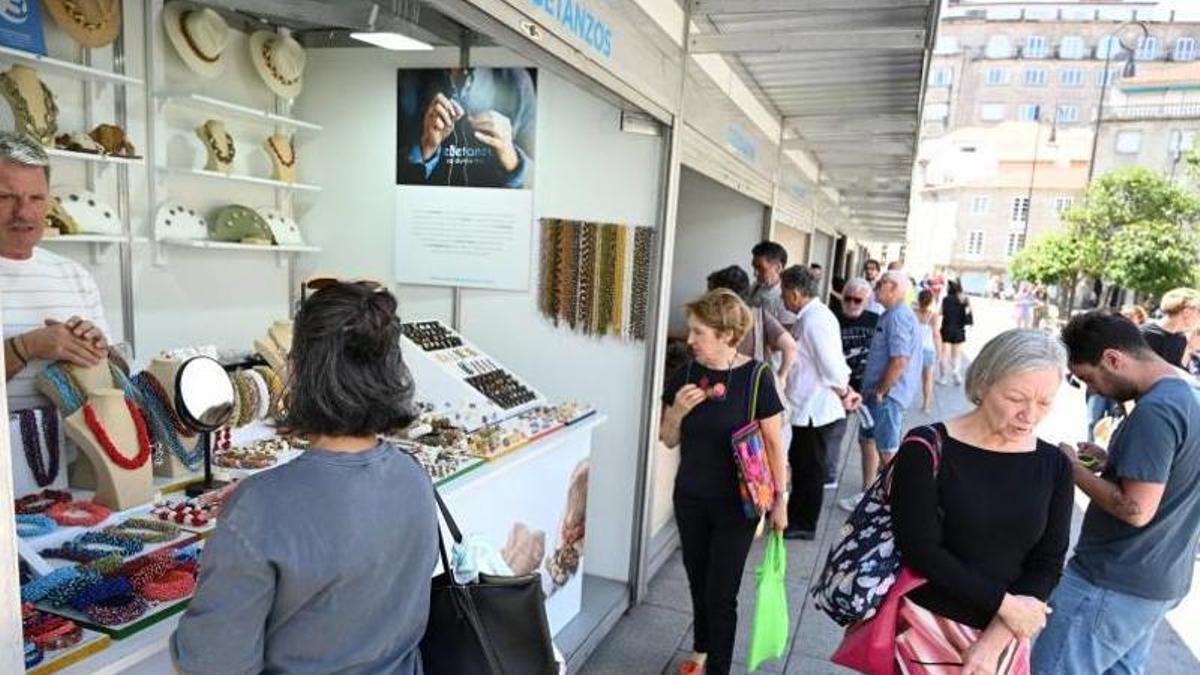 Multitud de curiosos observando los productos artesanos de A Chalana
