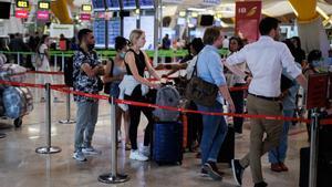 Varias personas hacen cola en el aeropuerto Adolfo Suárez