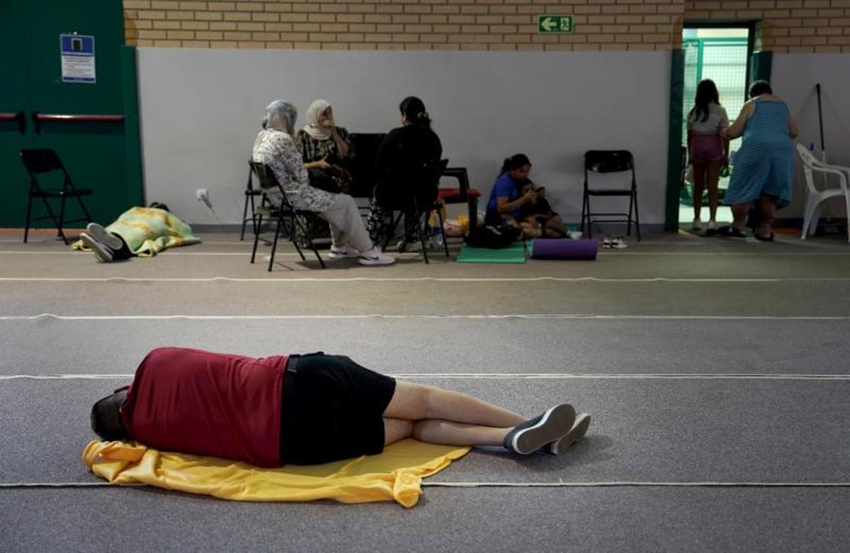Un vecino desalojado de una pedanía del incendio de Madrid duerme en el suelo, agotado, en el polideportivo de Villamanta.
