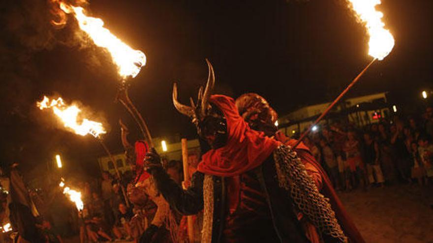 Los demonios lanzan fuego durante el correfoc en la playa del Portitxolet.