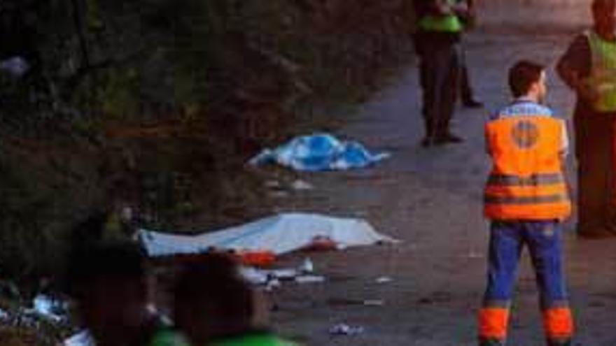 Sanitarios y guardias civiles, ante varios de los muertos, tapados con mantas.