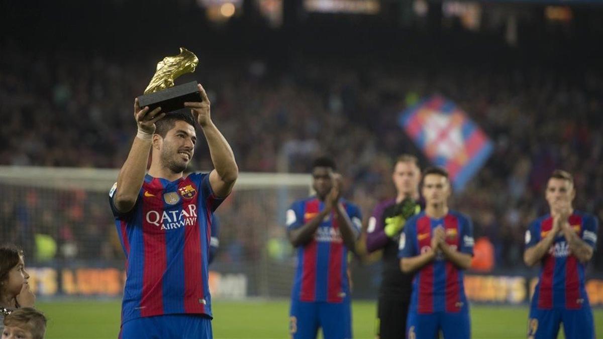 Luis Suárez exhibe el Balón de Oro conquistado de la temporada 2015-16 a la hinchada del Barça en el Camp Nou.