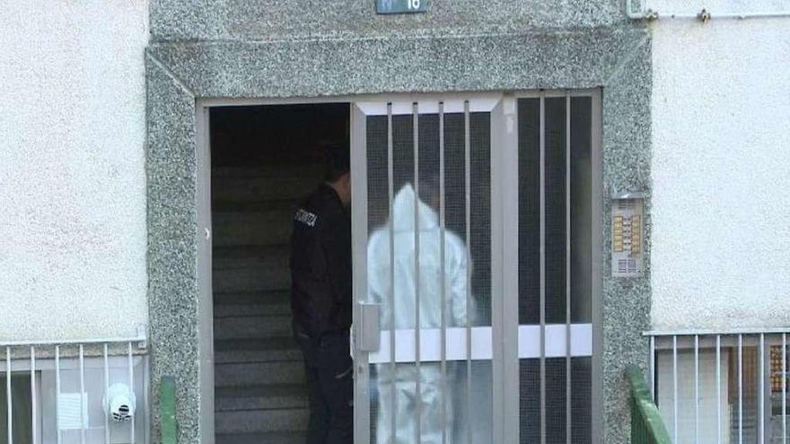 Agentes en el portal del edificio donde se produjo el crimen.