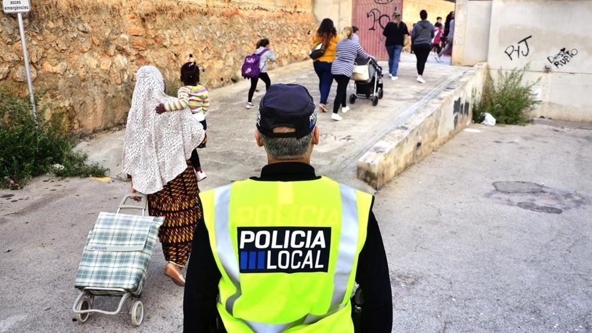 Un policia local observa la entrada de los ninos en un colegio de Palma