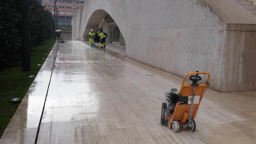 Dos operarios, ayer, durante las labores de abujardado de las baldosas de las vías públicas del entorno del palacio de Calatrava, en Buenavista.