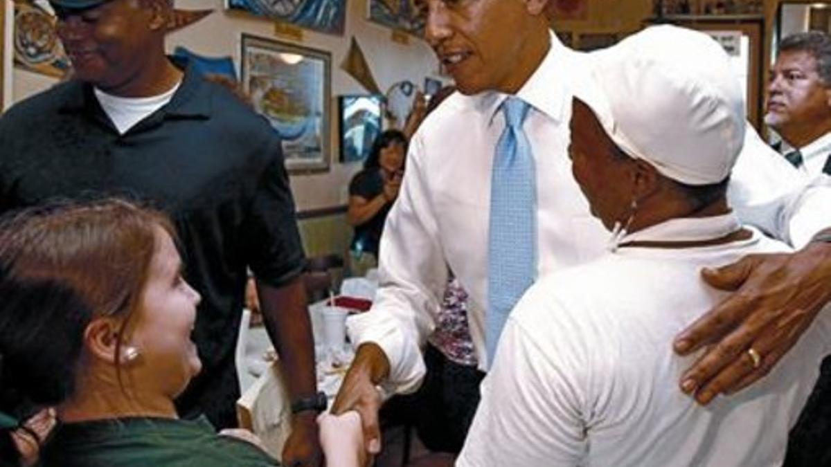 Obama saluda a la familia del dueño y al personal de una panadería y una taberna de Nueva Orleans, ayer.