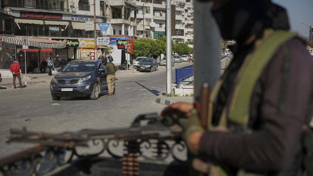 Un miembro de las fuerzas de seguridad sirias inspecciona un coche en un control en la región de Latakia, el pasado martes.