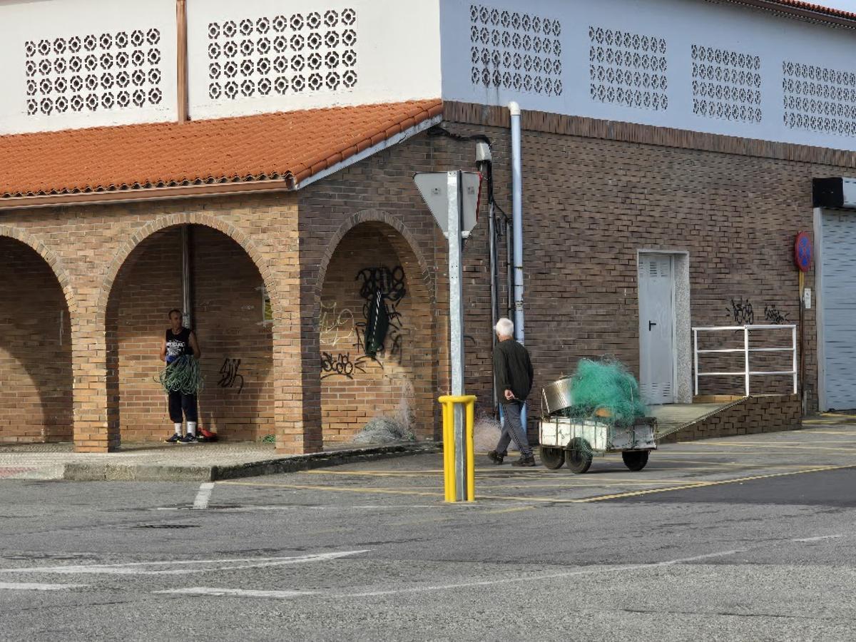 Un hombre reparandomiños y otro que le llevamás en un carrito.