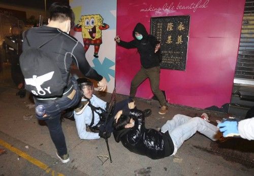 A protester kicks a policeman who has fallen down during a clash at Mongkok district in Hong Kong,