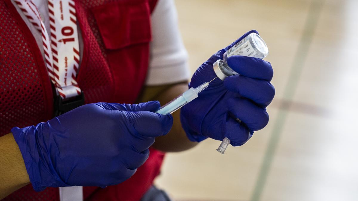 Una voluntaria de Cruz Roja prepara una dosis de la vacuna de Moderna contra el Covid-19 para un estudiante universitario en el campus de Ciudad Universitaria, a 14 de septiembre de 2021, en Madrid, (España).