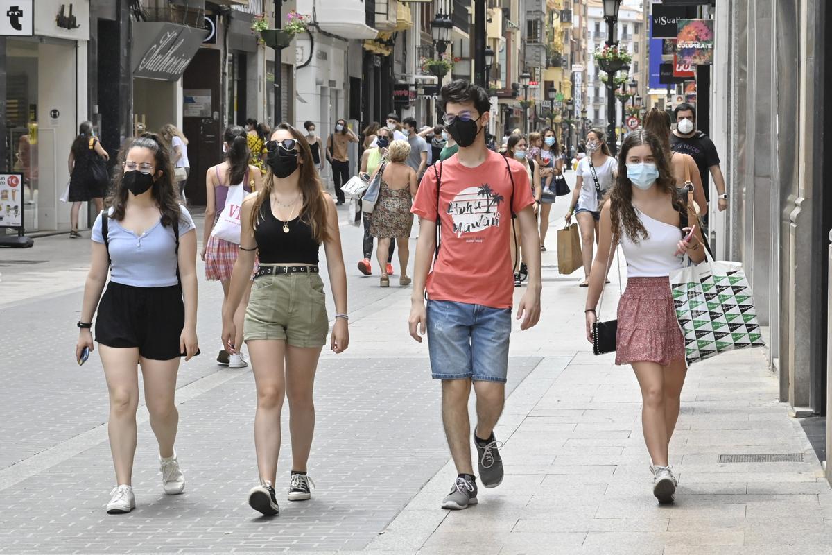 Varios jóvenes pasean por el eje comercial del centro de Castelló.