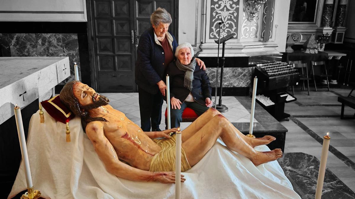 Dos vecinas, ante la imagen del Cristo.