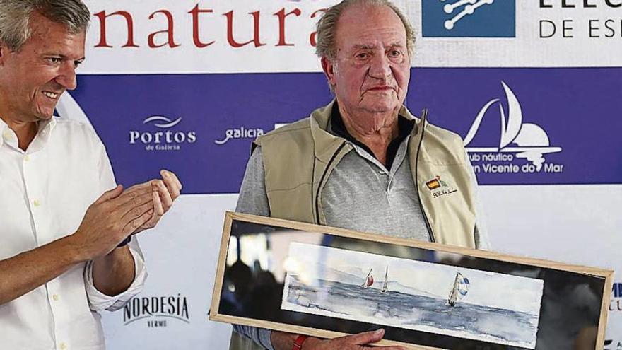 El Rey Juan Carlos porta el cuadro de Carlos Álvarez Besada que le regaló el Club Náutico. // Muñiz