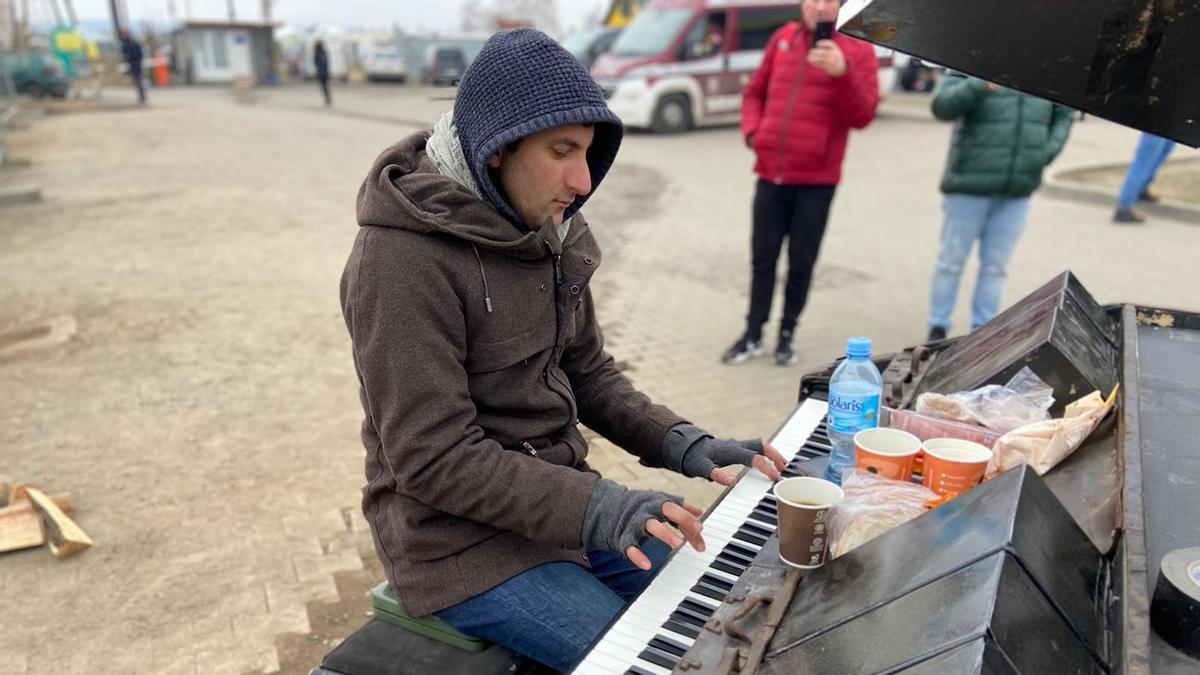 Davide Martello toca el piano en el paso fronterizo de Medyka, entre Polonia y Ucrania