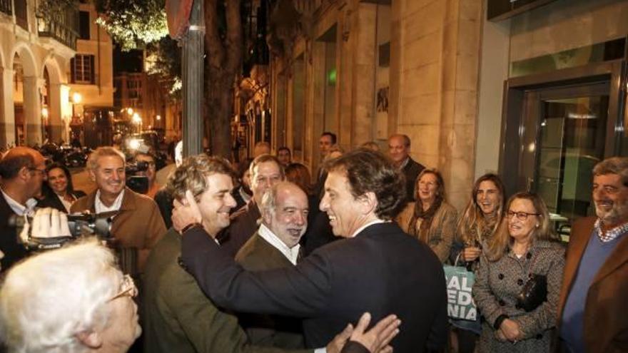 Isern saluda a un grupo de ciudadanos que le aplauden ante la sede del PP al término de la reunión.