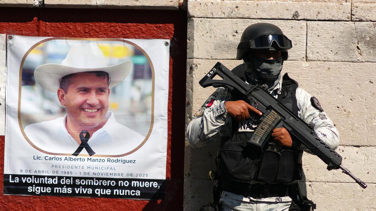 Un guardia junto a una imagen del alcalde asesinado Carlos Manzo Rodríguez en Uruapan, México.