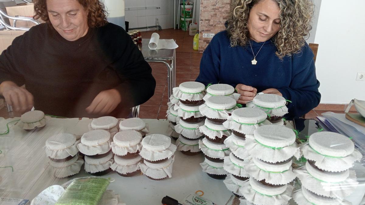 Dos comuneras de Baroña envasando la miel en los tarros que Sara y Fernando regalarán a los invitados a su boda.