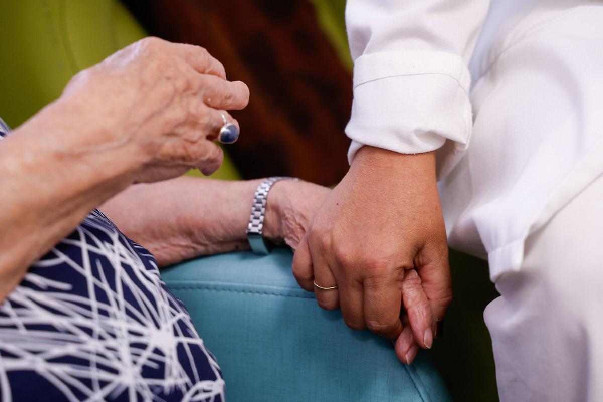 Una cuidadora toma la mano de una señora mayor en una residencia de Córdoba.