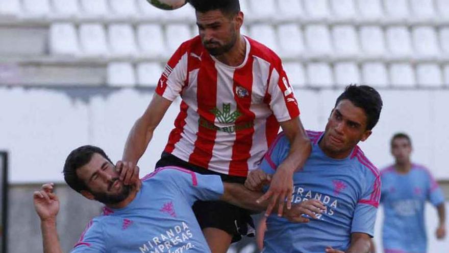 Revi salta entre dos rivales para cabecear un balón, ayer.