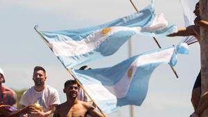 Messi, junto a sus compañeros, en el autobús de la celebración al lado de un seguidor subido en un poste.